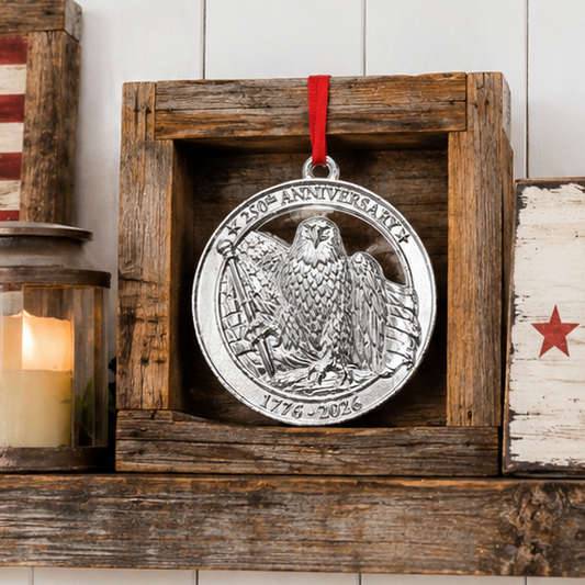 Silver USA 250th anniversary ornament with eagle design on a wooden shelf with American flags and decor.