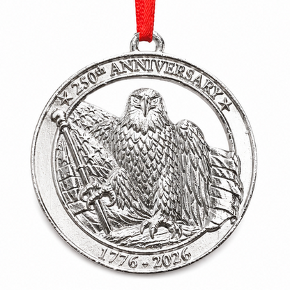 Silver anniversary ornament with eagle design on a wooden shelf with American flags and decor.