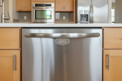 Dirty Clean dishwasher magnet on a black handle against a marble background