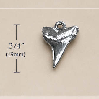Shark tooth jewelry set with pendant, necklace, and earrings on a beige background.